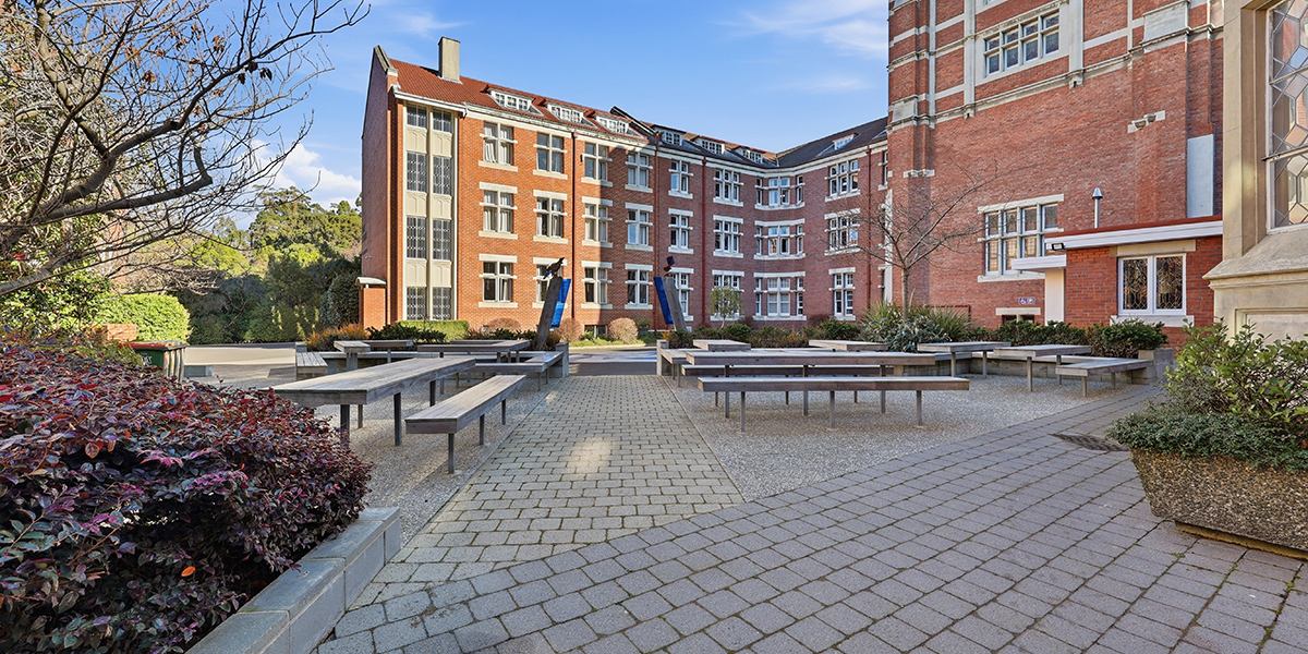 Outside courtyard with tables and College in the background
