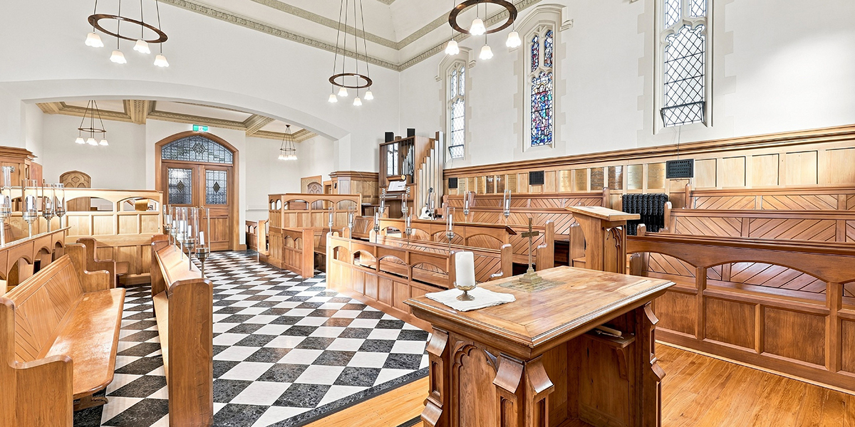 Chapel with wooden pews and black and white tiled floor
