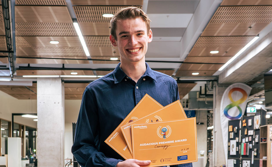 Josiah Bugden stading with his 3 certificates at the award presentation.