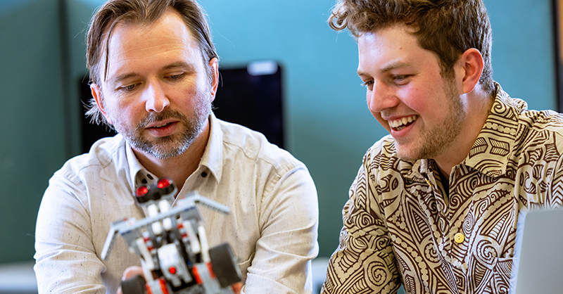 Student and teacher looking at robotics model