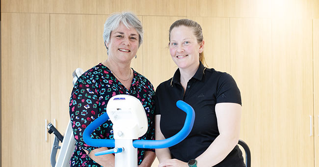 Two women are pictured with exercise equipment.