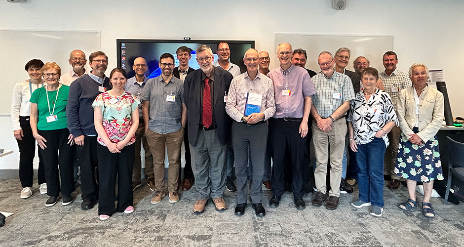 A group of people are pictured with a man holding a Festschrift.