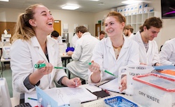 Students pipetting and laughing in an undergraduate biochemistry lab.