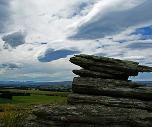 Precariously balanced schist at the apex of a tor overlooking the Strath Taieri Valley