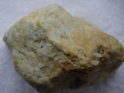 Fragment of quartz vein from a fault zone near Earnscleugh (piece is 5 cm across), with several visible gold particles (above the blue dot).