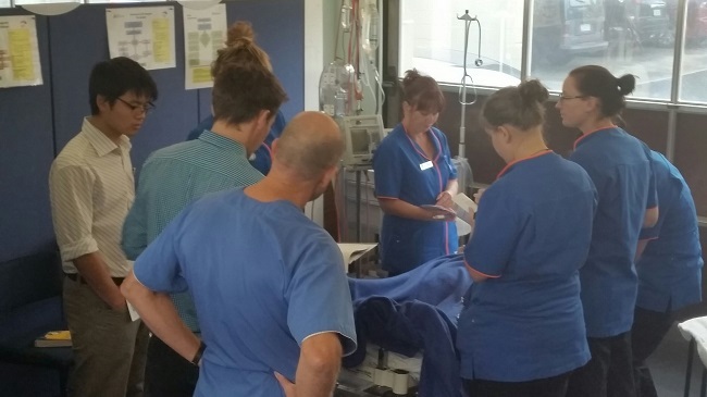 Joint Simulation image, with various professionals gathered around patient.