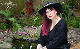 Dr Paula Toko King.sitting in a garden area with small fish pond image