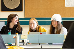 three students sitting in classroom