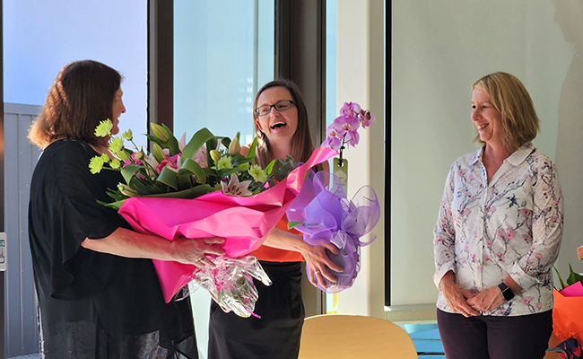 Professor Rich recieving flowers from Client Service Adminstrator Cate Lippers and Head of Department Professor Julia Horsfield image