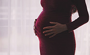 A pregnant woman with her hands on her belly stock image thumbnail