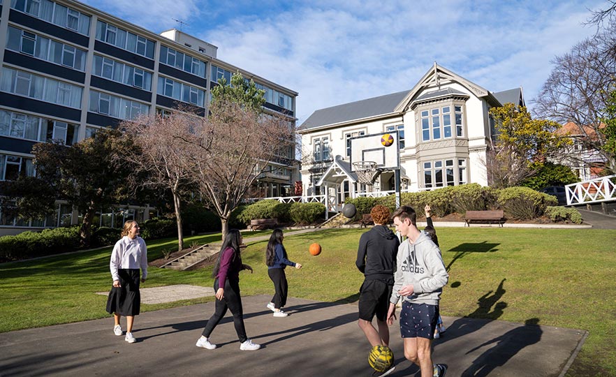 Students playing basketball outside Studholme College buildings image