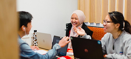 International students conversing in a study booth image