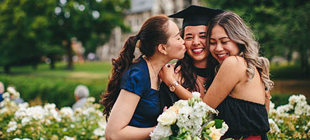 New graduate being hugged by mother and sister