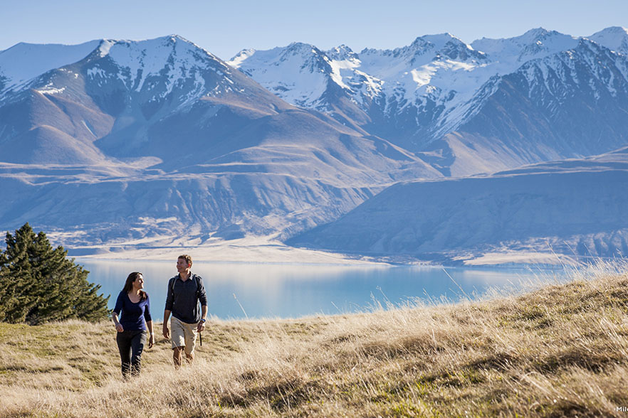 Two people walking with Aoraki-Mount Cook in the background