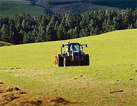 a photo of a tractor feeding out a bale of hay
