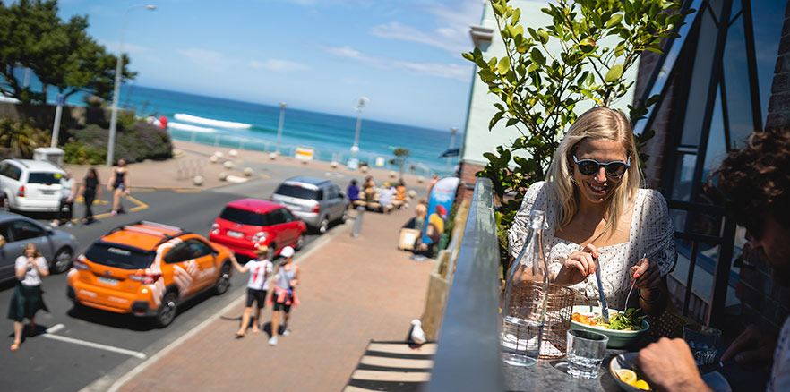 People eating on the balcony of Starfish Cafe at Saint Clair. Photo credit: Dunedin NZ.