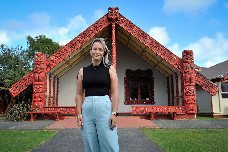 Grace Davies standing outside of a marae