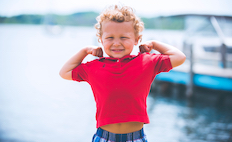 Child in a red shirt near a lake