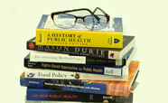 Eye glasses on top of a pile of books about public health thumbnail 