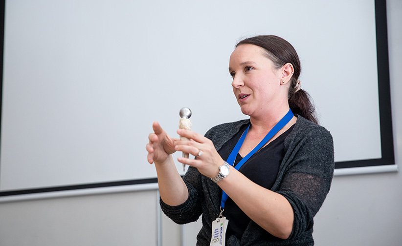 Dr Gabriella Lindberg holding a hip implant image