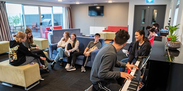Te Rangi students playing piano in common room